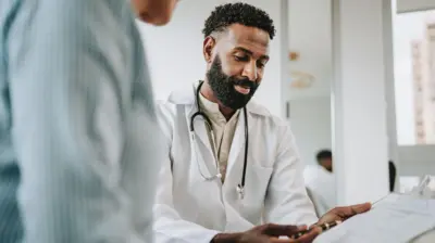 Doctor talking to patient holding clipboard