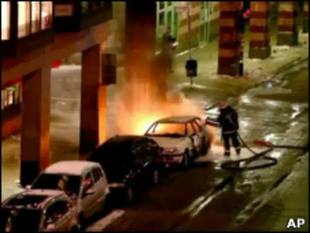 Полицейский тушит машину после взрыва