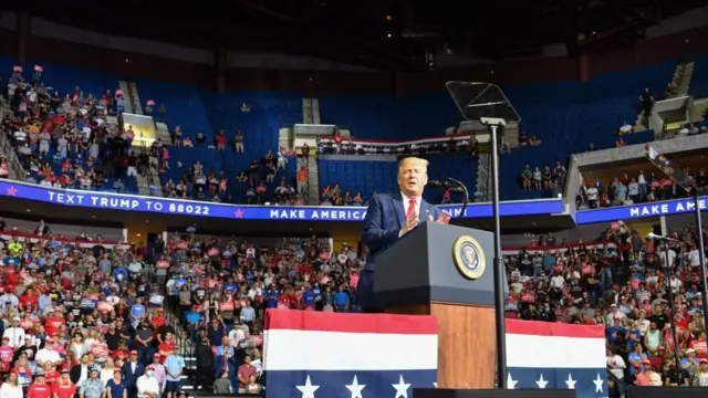 Trump speaking in Tulsa with rows of empty seats in the background