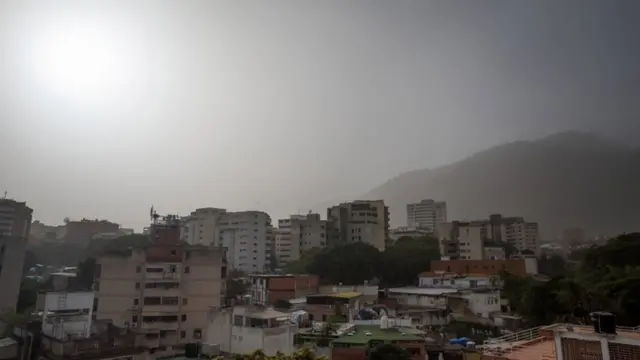 Расположенные на холмах пригороды столицы Венесуэлы Каракаса в воскресенье затянула дымка, 21 июня