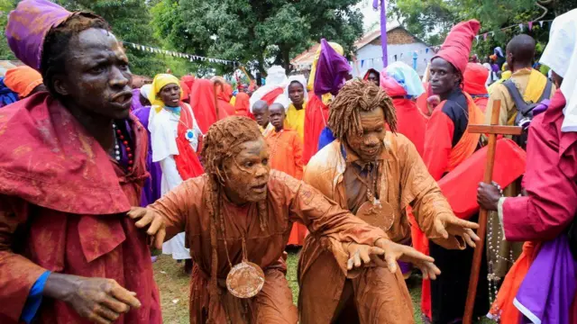 Мужчины на западе Кении покрывают себя грязью, чтобы принять участие в праздничной процессии в Рождество