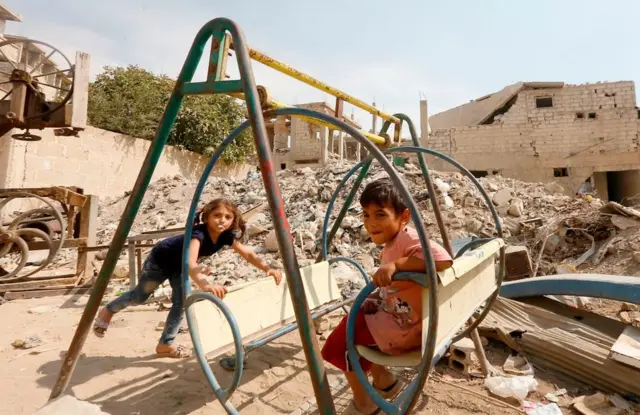 Syrian children play amidst badly damaged buildings in Zabdin, in the eastern Ghouta region on the outskirts of Damascus, on October 08, 2018