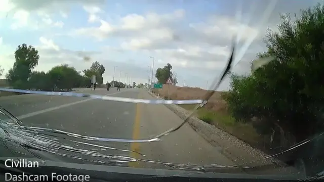 Вид из машины на трех мужчин, идущих по дороге