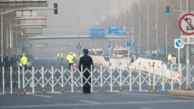 Китайские полицейские блокируют улицу рядом с отелем Дяоюйтай, по которой проедет кортеж, предположительно, северокорейских представителей