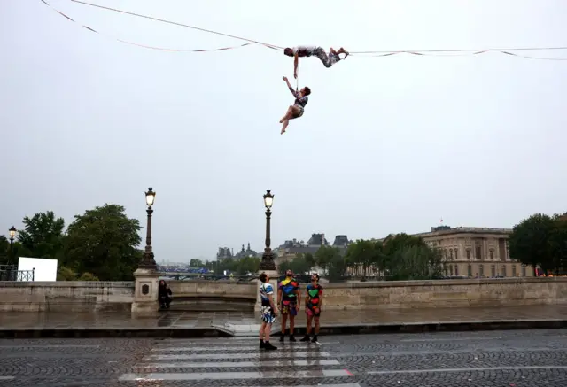  Tightrope walker Nathan Paulin performs on a high rope during the athletes’ parade on the River Seine near the Supreme Court during the opening ceremony of the Olympic Games Paris 2024