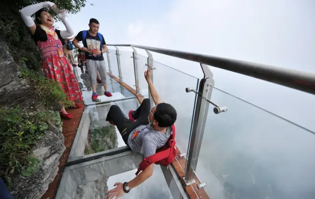 Туристы фотографируются на переходе в Национальном парке на горе Тяньмэнь
