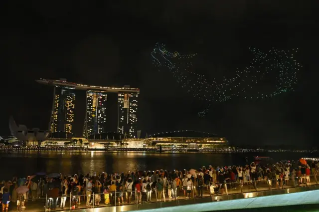 Жители Сингапура смотрят шоу, которое называется «Легенда о Воротах Дракона»