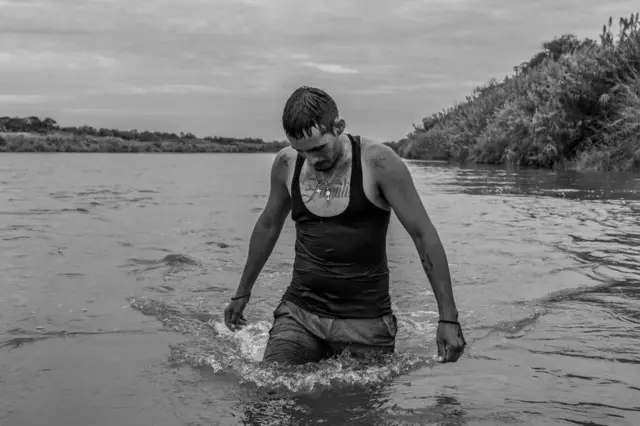 Венесуэлец Карлос Мендоса пересекает реку Рио-Гранде, чтобы попросить убежища в США