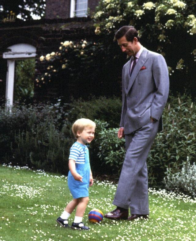 Принц Чарльз играет в мяч со своим сыном, принцем Уильямом в саду около Кенсингтонского дворца