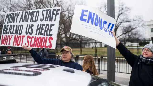 A demonstrator supporting gun control attempts to cover a sign held by a counter-protestor supporting gun rights during a 'lie-in' demonstration supporting gun control reform near the White House on February 19, 2018 in Washington, DC. According to a statement from the White House, 'the President is supportive of efforts to improve the Federal background check system.', in the wake of last weeks shooting at a high school in Parkland, Florida.