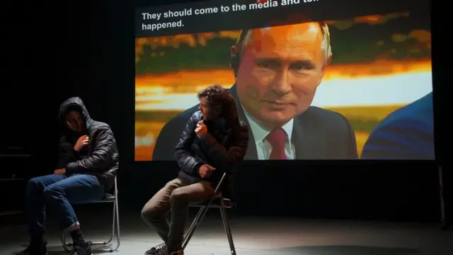 Джеймс Марлоу и Оливер Беннетт на сцене на фоне видеорепортажа с Путиным