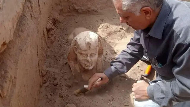 An archaeological worker unearthing a Sphynx statue during in Egypt