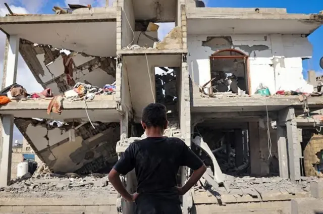 Un enfant devant une maison détruite à Gaza