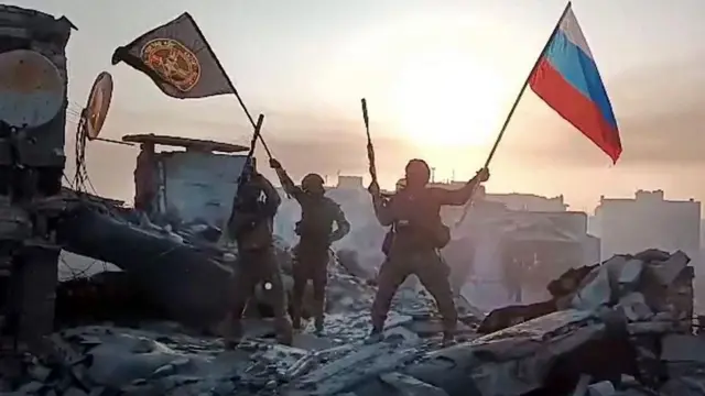 Вагнеровцы на руинах с флагами России и ЧВК