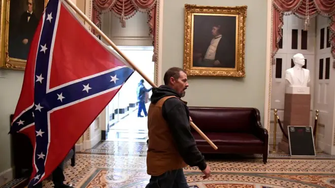 A protester carries the Confederate flag after breaching US Capitol security