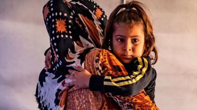 Displaced woman and child in Tuwaynah, north-east Syria (file photo)