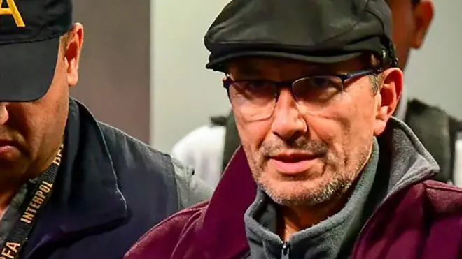 Argentine former police officer Mario Sandoval is escorted by police officers upon his arrival at Ezeiza airport in Buenos Aires on December 16, 2019, after France extradited him to face trial over the disappearance of a student