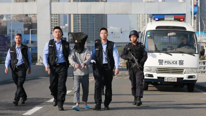 深圳警方把珠寶店劫案其中一名嫌疑犯帶到粵港分界，並移交香港警方。