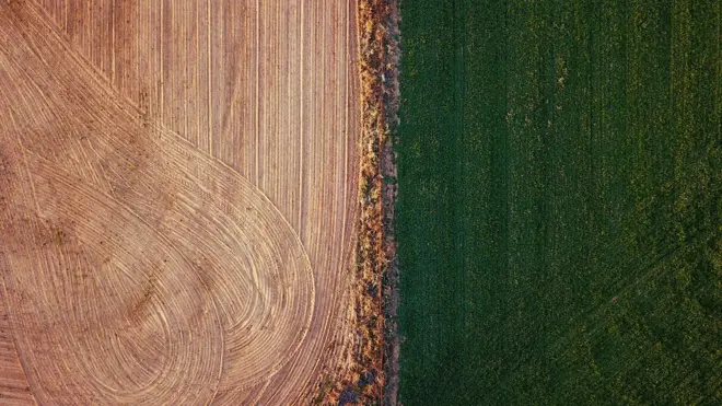 An irrigated paddock can be seen next to a ploughed paddock on a farm located on the outskirts of the town of Mudgee