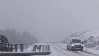 Van drives down snow-covered road