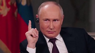Vladimir Putin raising finger during interview with Tucker Carlson