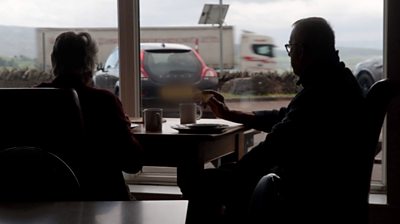 A couple gazing out of the window at a motorway truck stop near Penrith