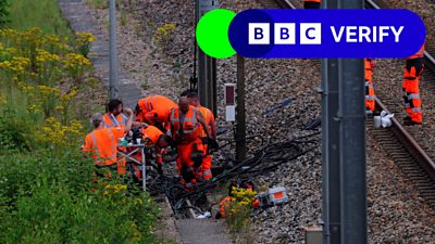 Workers wearing high-visibility clothing at the site where vandals targeted France's train network