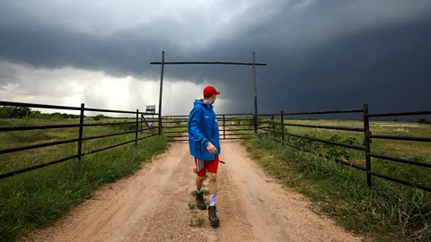 Getty Images Man looking back at tornado forming (Credit: Getty Images)