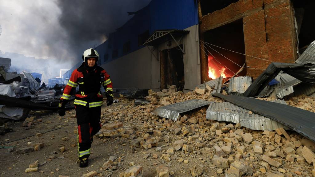 A firefighter works at a site of a warehouse heavily damaged during a Russian missile strike in Kyiv