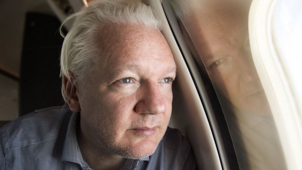 WikiLeaks founder Julian Assange looking out of the window of a plane while approaching Bangkok for a layover at Don Mueang International Airport, Thailand