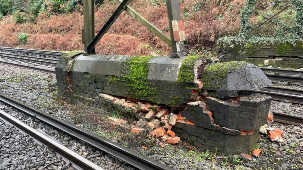 The foundation of a steel passenger footbridge, a moss covered brick structure crumbles
