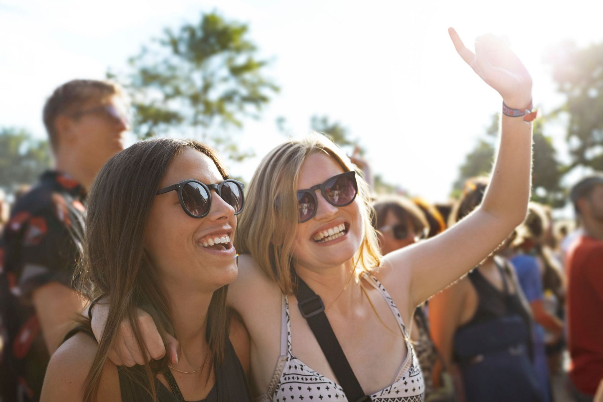 Friends hanging out at big outside music festival, in the sunset - stock imahe