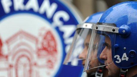 Turkish riot police officers stand guard in front of the French consulate in Istanbul, 22 December