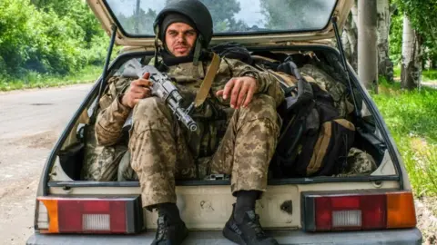 Getty Images A Ukrainian soldier sits in the boot of a car