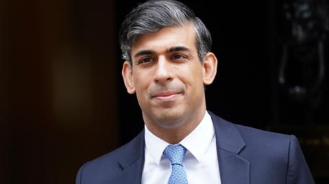  Rishi Sunak wearing a suit and blue tie is seen leaving 10 Downing Street during his final days as prime minister
