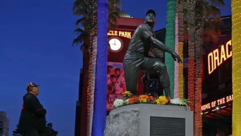 Baseball fan at Willie Mays statue in San Francisco