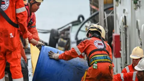 Crew of a private company loads a barrel of oil spill dispersant to be used in the oil spill response