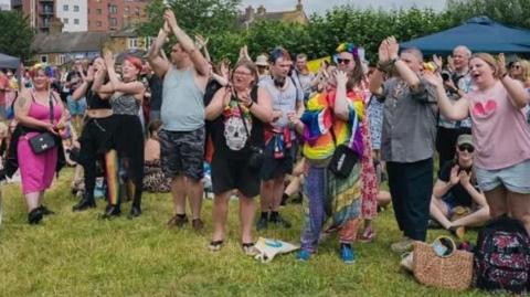Pride festival-goers applauding