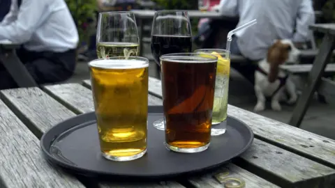 A tray of drinks on a beer garden table, with beer, wine, and some soft drinks