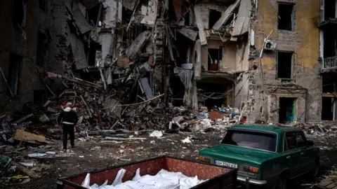 Getty Images A man picks up personal belongings from the apartment he used to live in in Kramatorsk, Donetsk