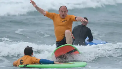 Sir Ed Davey surfing during a visit to Cornwall on 2 July