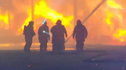 Firefighters trying to put out a blaze in Chile