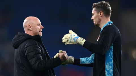 Robert Page shakes hands with Wayne Hennessey