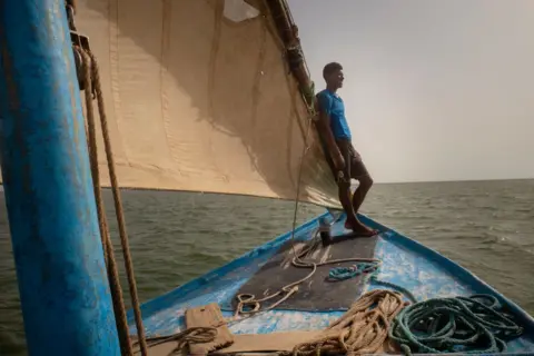 MICHELE CATTANI/AFP A fisherman stands at the front of a sailboat n the Banc d'Arguin National Park, Mauritania - Friday 19 July 2024