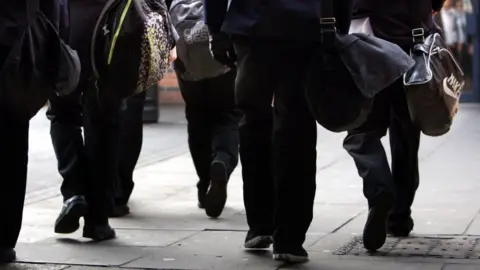 File image of anonymous pupils walking with school bags