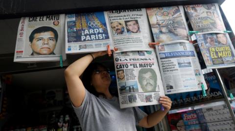 A newspaper seller arranges newspapers reporting the El Paso, Texas, U.S., arrest of Mexican drug lord Ismael "El Mayo" Zambada 