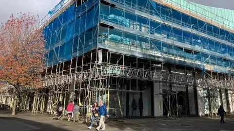 Before: Buildings covered in scaffolding