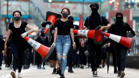 Reuters Protesters walk down the road with traffic cones to build a barricade in Causeway Bay, Hong Kong, China November 11, 2019