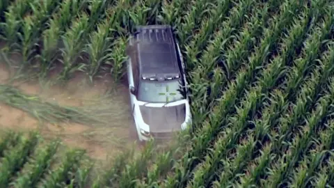 A four-wheel-drive car in a field of crops