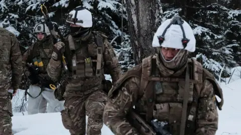 EPA Four British Army soldiers on a military exercise in Estonia, they are in full camouflage gear in the snow and carrying rifles